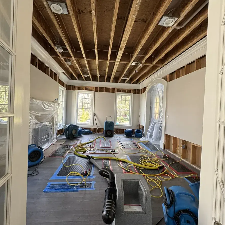 Gutted Mount Juliet living area with air movers and drying mats running after a water loss